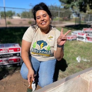 Woman posing for a photo and holding up a peace sign for day of giving.